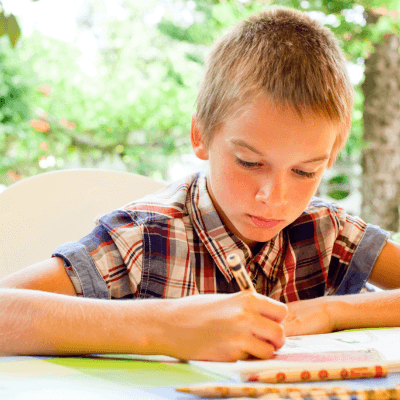boy concentrating intently on writing