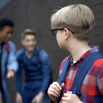 boy with glasses being laughed at